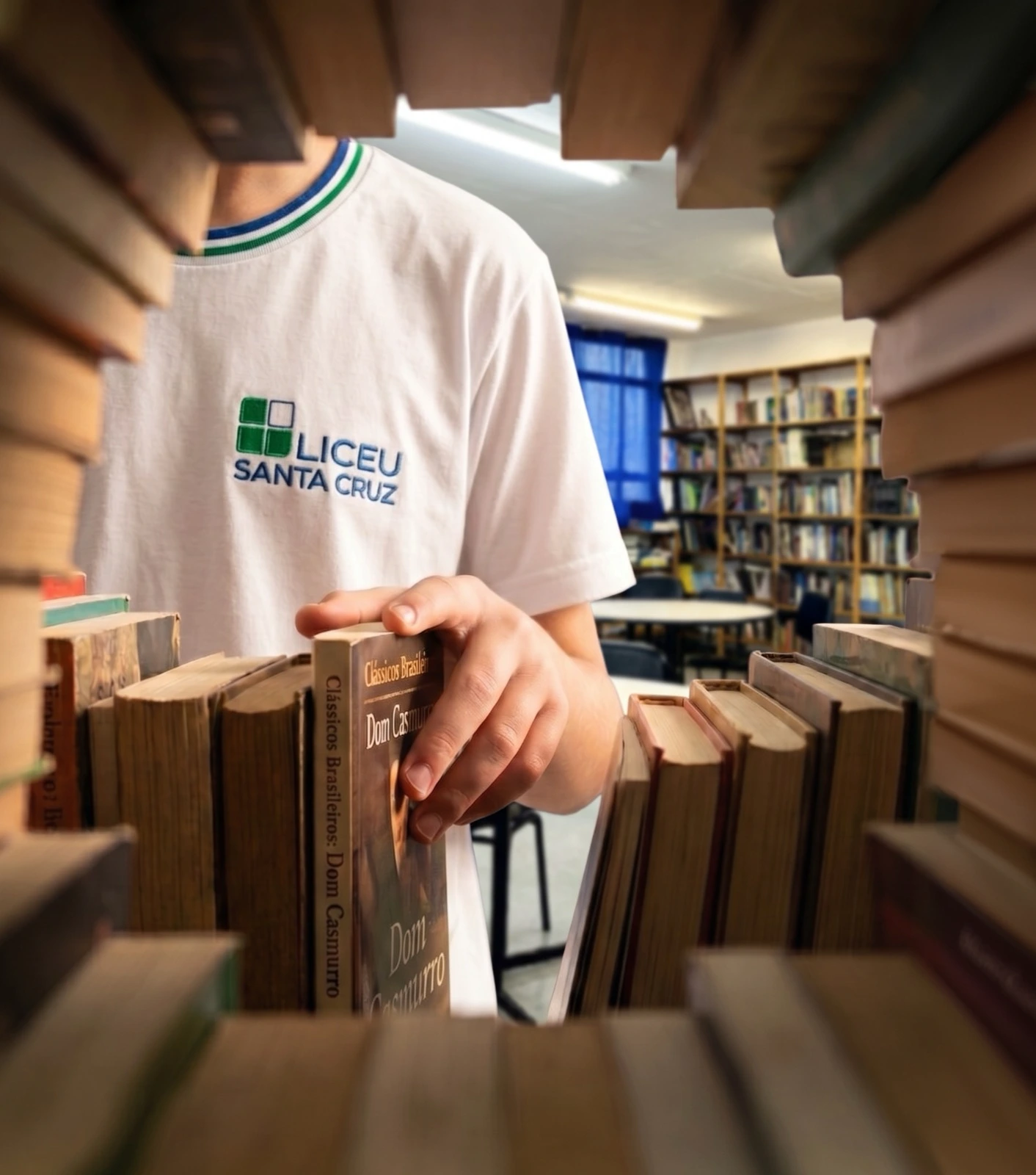 Mão escolhe um livro em uma estante.
