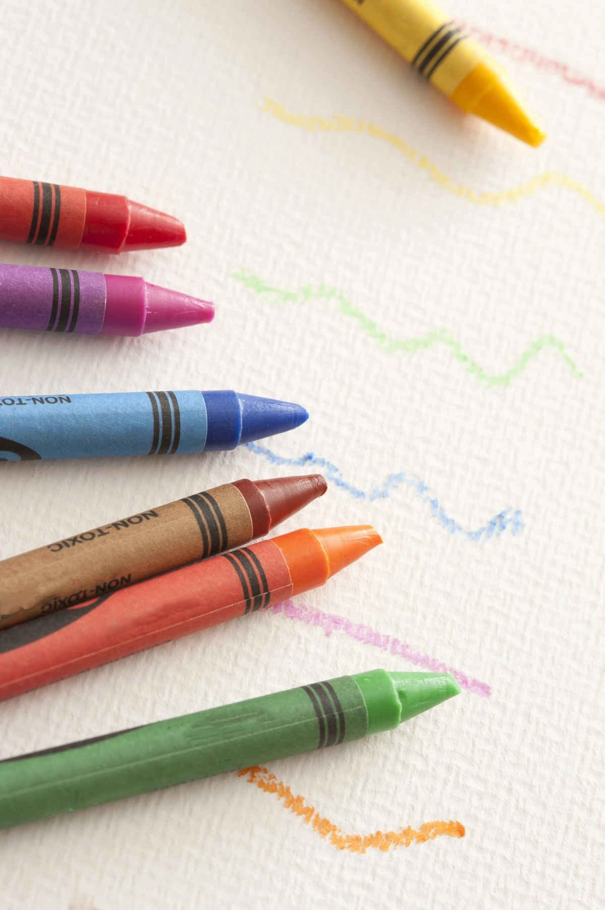 Gizes coloridos sobre desenhos no papel.