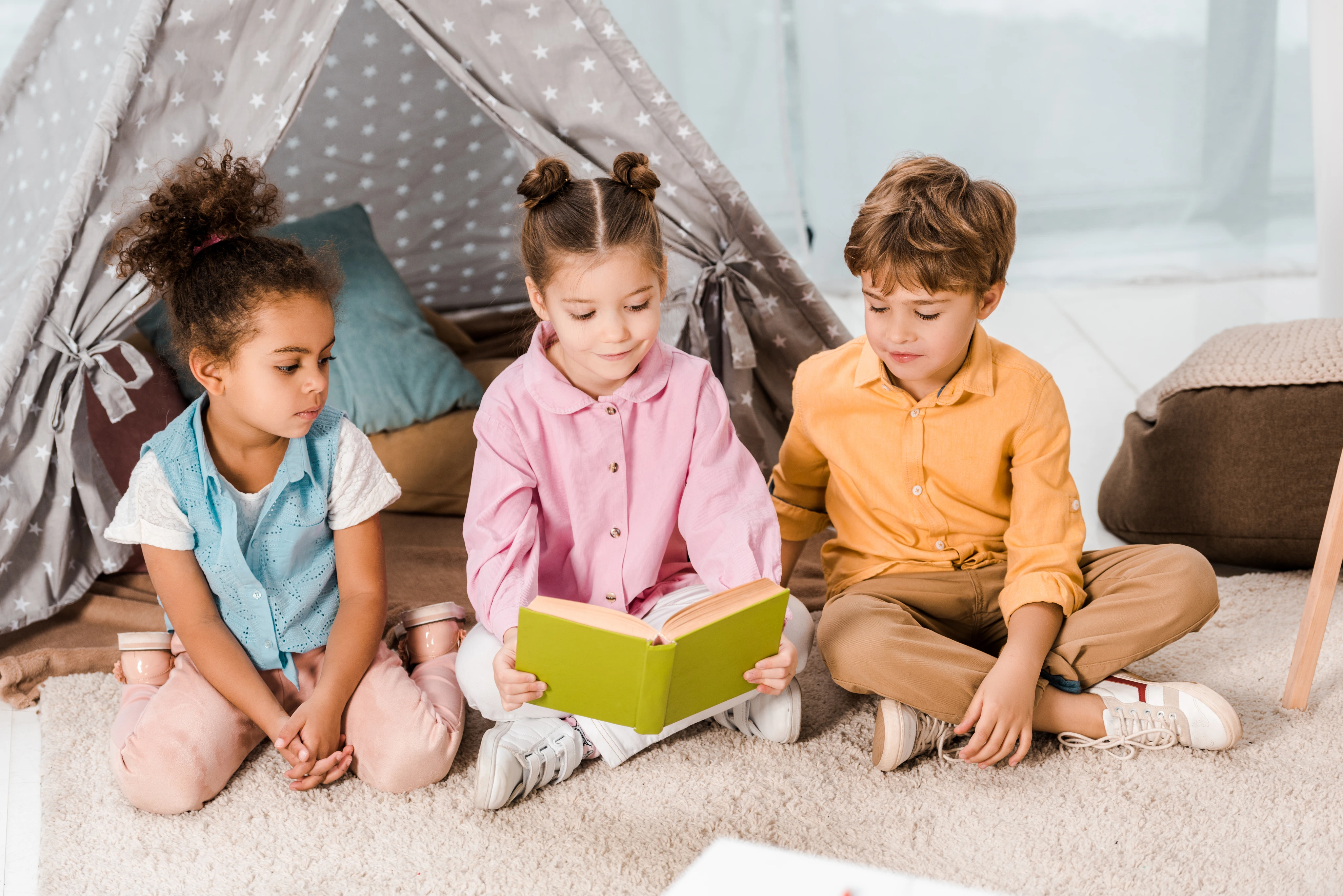Crianças compartilham livros com uma educadora.