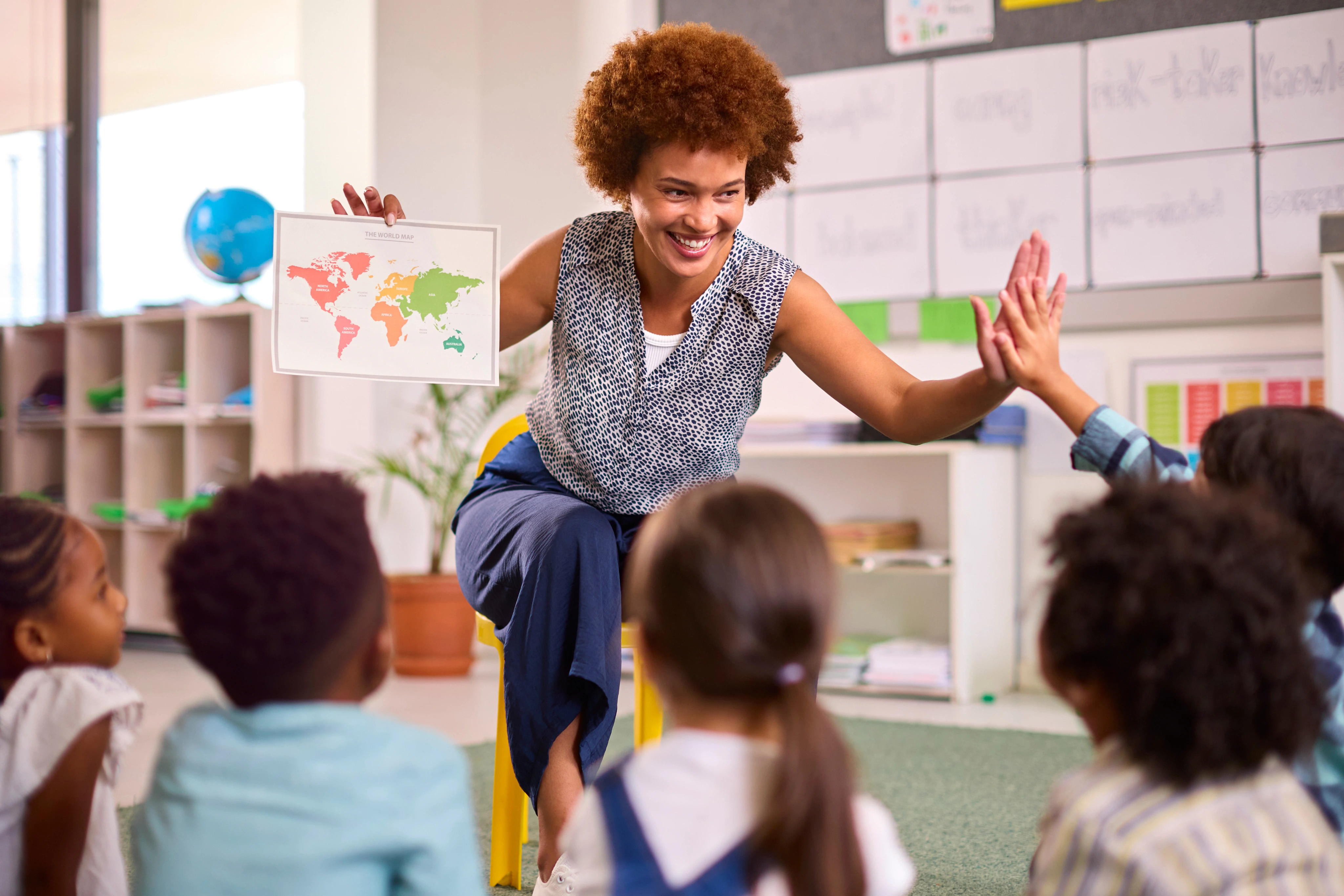 Educadora acompanha uma atividade de crianças na sala de aula.